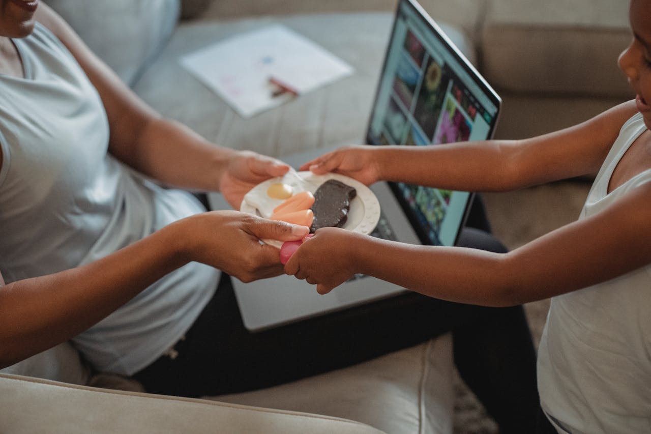 A mother and child enjoy sharing sweet pastries on a couch, highlighting family bonding in a cozy setting.
